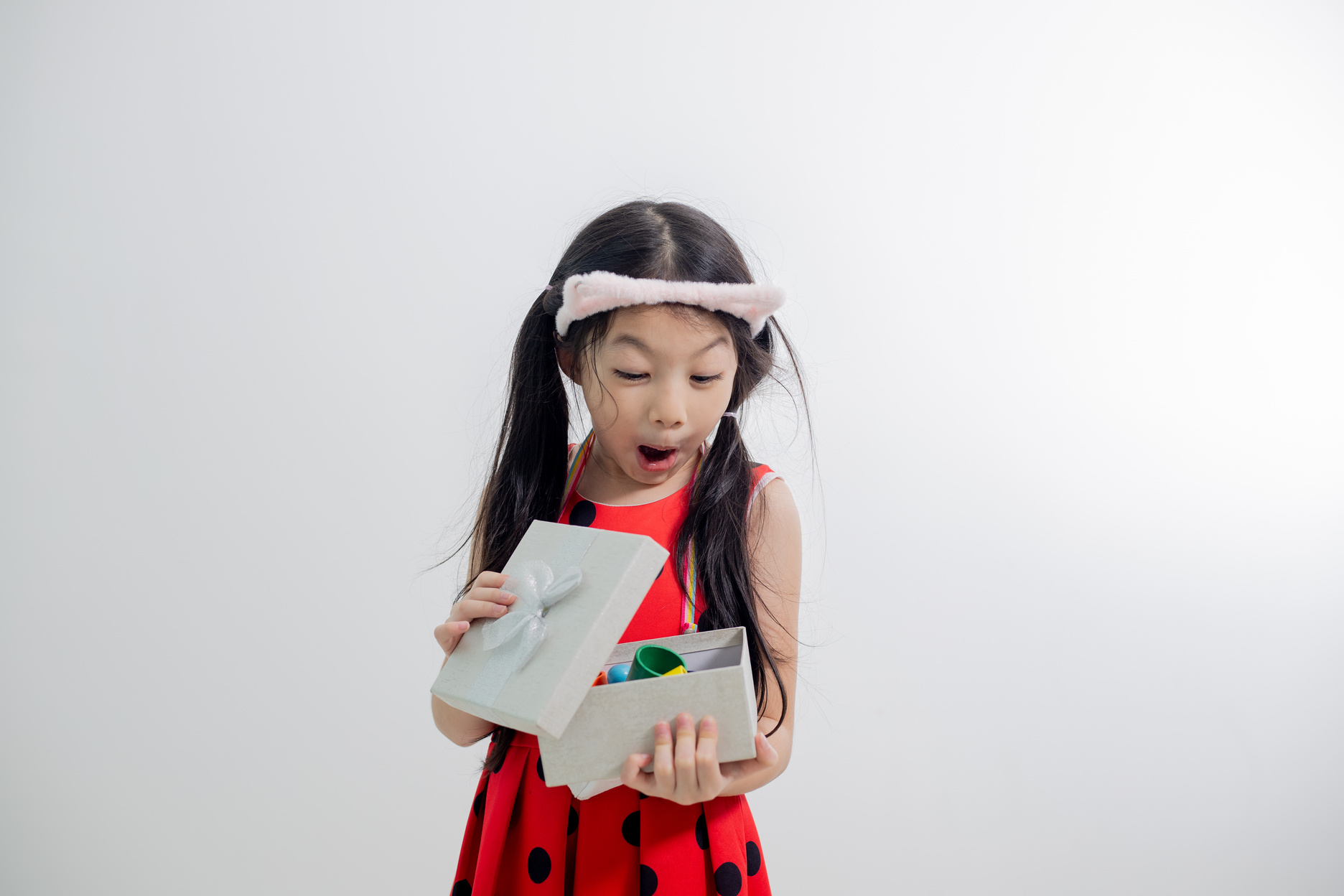 Asian happy child girl opening gift box.