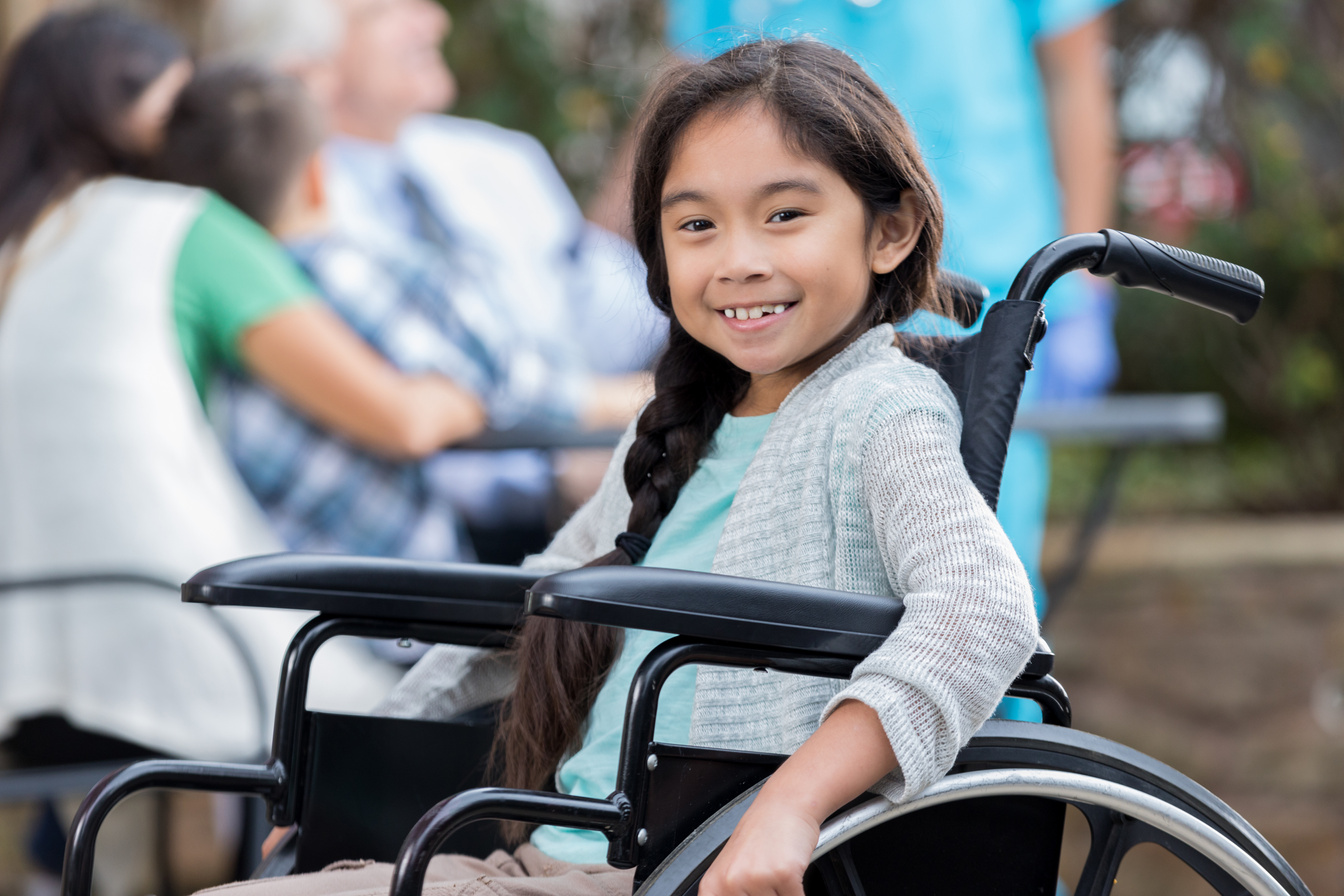 Confident little girl in wheelchair at outdoor clinic