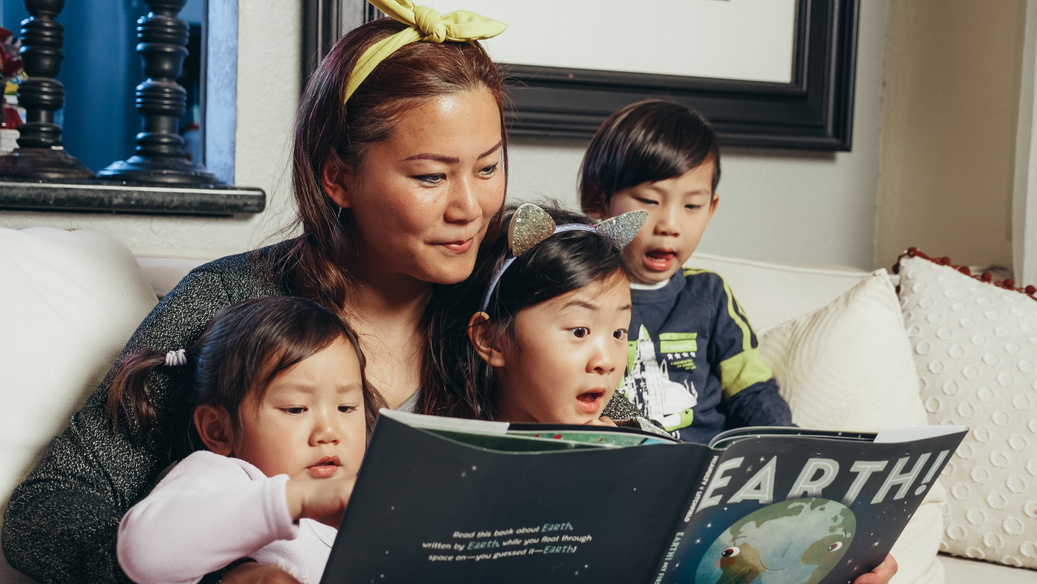 Woman Reading A Book With Her Kids