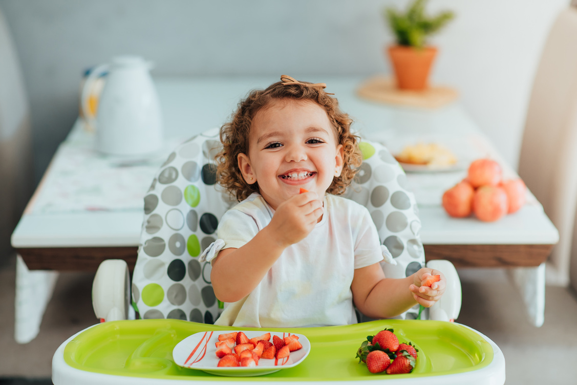 Child eating strawberry for breakfast, healthy and vegan eating concept